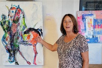 Ausstellung auf Burg Schönfels: Riesengiraffe frisst Buchstaben - Brigitte Wolf vor dem Bild „Keep on Running“, einer Mischtechnik auf Leinwand.