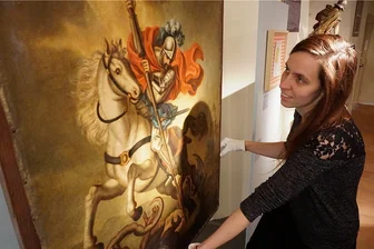 Ausstellung auf Schloss Voigtsberg widmet sich Heiligen Georg - Museumsleiterin Tina Reitz mit einem Ölgemälde mit dem Motiv des Heiligen Georgs und dem Drachenstich.