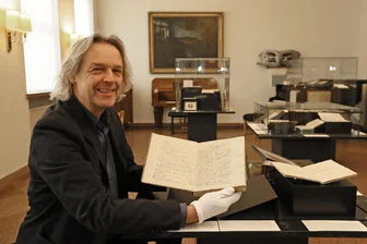 Ausstellung im Schumannhaus: Wo es Schüler Robert nach Ansicht seines Lehrers mit der Heimatliebe übertrieben hat - Thomas Synofzik mit dem Schulaufsatz Robert Schumanns, in dem er die Region Zwickau in höchsten Tönen lobte. Der Komponist ließ seine jugendlichen Selbstzeugnisse in späteren Jahren selbst zum Buch binden.
