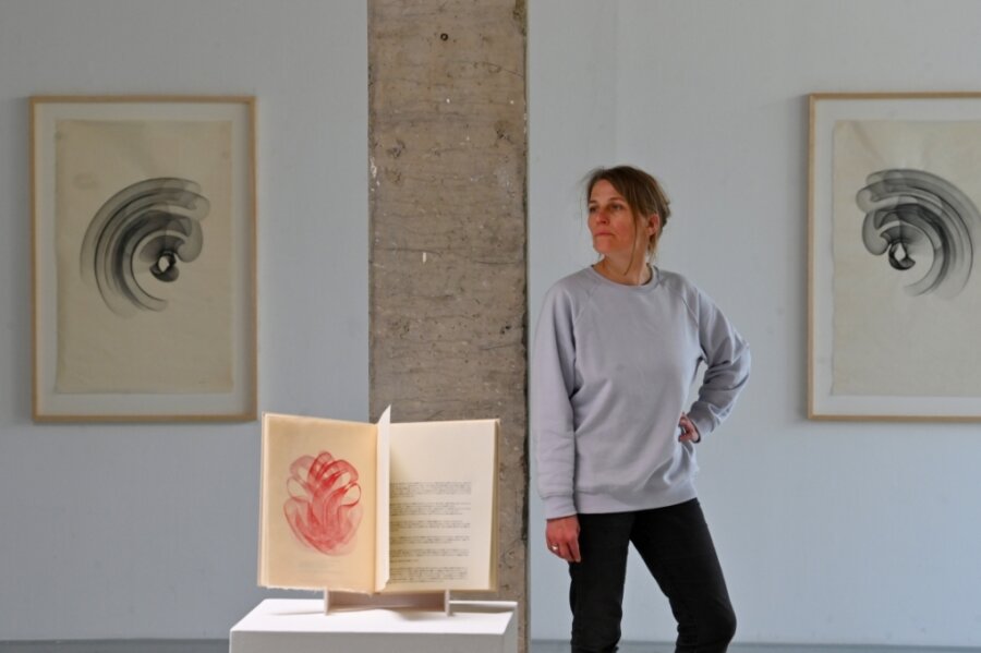 Ausstellung zeigt den Zauber sanfter Kurven auf zartem Papier - Galeristin Henriette Schneidewind neben einem Buch mit chinesischen Texten, das von der Leipziger KünstlerinMaribel Mas illustriert wurde. 