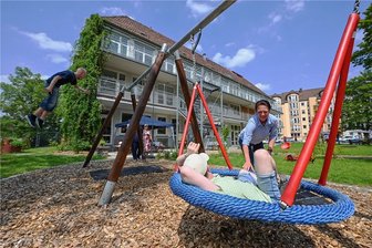 Autismuszentrum Chemnitz-Bernsdorf: Wo ein Außenbereich zu einer grünen Ruheoase wird - Das Autismuszentrum hat seinen Garten mit Spielgeräten und vielen Pflanzungen umgestaltet und verschönert. Mitarbeiterin Nicole Wyrzykoski schiebt eine Schaukel an, die aufgearbeitet wurde.
