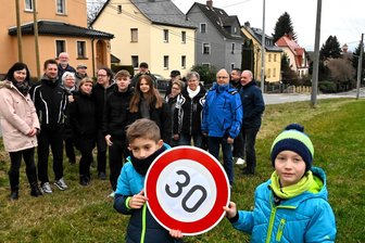 Auto landet auf Treppe zum Haus: Anwohner fordern nach Unfall bei Mittweida schärfere Kontrollen - Die Anwohner der Neusorger Straße in Altmittweida fordern mehr Tempokontrollen auf diesem Abschnitt vor ihren Häusern. Am zweiten Weihnachtstag kamen die Bürger dort zusammen, Lenny (l.) und Charly haben ein Schild gemalt.