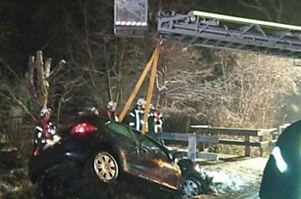 Auto landet im Bach - Einsatzkräfte der Feuerwehr holen das Auto aus dem Bach. Der Fahrer wurde bei dem Unfall schwer verletzt.