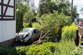 Auto schießt durch Zaun, fällt Baum und prallt gegen Hauswand - Fahrer unverletzt -
