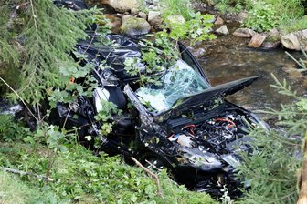 Auto stürzt im Erzgebirge in Fluss: Fahrerin von Ersthelfern befreit - Die Fahrerin war mit ihrem Auto erst gegen Bäume geprallt, bevor das Fahrzeug ins nahe Schwarzwasser stürzte.