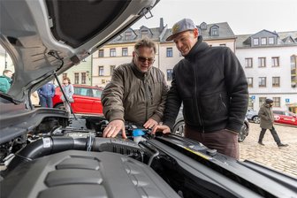 Autofrühling Auerbach: Warum heiße Schlitten nicht bei allen Besuchern ziehen - Udo Kraus (links) vom Autohaus Zeidler aus Mylau blickt mit Fabian Krause unter die Motorhaube eines Skoda.