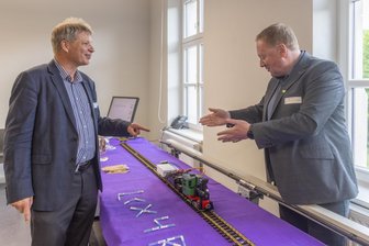 Autonome Züge ab Annaberg? Wie es mit dem Bahn-Forschungscampus im Erzgebirge weitergeht - Oliver Michler, Professor an der TU Dresden, und Andreas Küster von MRK Management Consultants, präsentieren ein abstrahlendes Kabel, das eine durchgängige Mobilfunkverbindung im Zug ermöglicht.