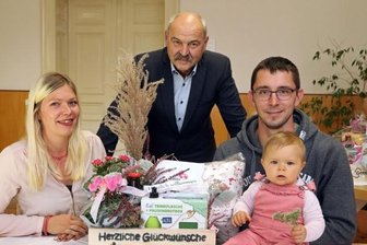 Babypaket: Bald gibt es überall einen Willkommensgruß - In Remse haben sich Franziska Gawlick und Michael Dietrich gemeinsam mit Tochter Emilia (Foto vorn von links) das Babypaket bei Bürgermeister Joachim Schuricht abgeholt. 