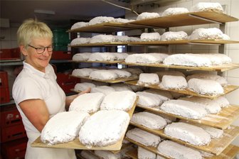 Backen, buttern, zuckern: Stollen aus dem Café Friedrich in Augustusburg haben deutschlandweit Fans - Christiane Doege schiebt die fertigen Stollen im Café Friedrich in Augustusburg auf Holzbrettern zum Erkalten in die sogenannten Schragen.