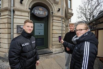 Backhendl statt Tapas: Zwickau bekommt "Steyr Almgasthof" - Emily Anders und Robbie Keßler (Mitte) sowie Eric Brückner scannen schon mal vorfreudig den QR-Code des angekündigten neuen Restaurants am Zwickauer Hauptmarkt.