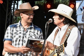 Bäckerei-Fete mit Tom Astor sorgt für Partystimmung in Zwota - Mit einem großen Fest wurde am Samstag in Zwota das Jubiläum 20 Jahre Landbäckerei Behrendt gefeiert. Im Foto: Umjubelter Stargast war die Country-Legende Tom Astor, der den Inhaber Frank Behrendt (links) mit einem Buch über sein 50-jähriges Bühnenleben überraschte.
