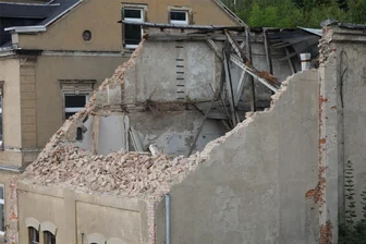 Bagger reißt marodes Haus an Bahnhofsbrücke in Aue nur zur Hälfte ab: Bleibt das jetzt so? - Der obere Teil des Gebäudes in Aue war abgerissen worden, weil der Giebel laut Stadtverwaltung einzustürzen drohte.