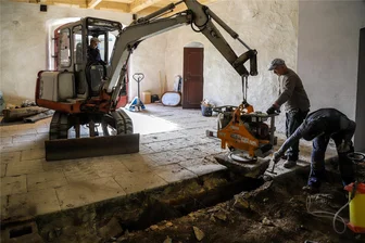 Bagger steht im Flur: Bauarbeiten in einem der ältesten Gebäude der Stadt Aue gehen jetzt bis auf den Grund - Steinplatte für Steinplatte wird der Fußboden im Eingangsbereich entfernt. Danach wird die Erde darunter weggebaggert. Im Fußboden soll eine Heizung verlegt werden.