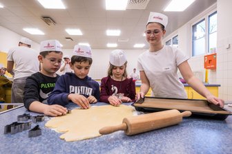 Basteln, Backen, Singen: Große Schüler stimmen kleine Schüler im Erzgebirge auf Weihnachten ein - Len, Alfred, Ella von der Grundschule Neustädtel haben gemeinsam mit Caycee Schubert (v. l.) beim Weihnachtsprojekt am BSZ Schneeberg Plätzchen gebacken.