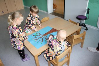 Bastelschürzen für Kita-Kinder in Langenbernsdorf - Drei Kinder mit den frisch übergebenen Schürzen beim Basteln.