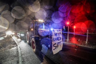 Bauernproteste bei Zwickau: Traktoren versperren fast alle Auffahrten auf die A 4 und A 72 - Protest an der A 4 bei Hohenstein-Ernstthal. Am Traktor befindet sich ein Plakat mit der Aufschrft „Wir habens satt.“