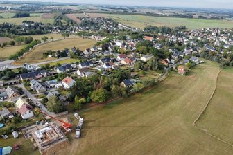 Bauland für Eigenheime: Mühlau verkauft günstig an junge Familien - Am Anton-Günther-Weg in Mühlau gibt es eine Reihe von Wohnhäusern. Ehemalige gepachtete Gartengrundstücke, die in der Mitte des Fotos zu sehen sind, sollen jetzt mit Eigenheimen bebaut werden. Ein Wohnhaus gegenüber entsteht zurzeit.
