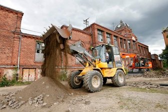 Baustart für Sachsens größte Kita - Zwei Bagger reißen die Pflasterung auf dem Vorplatz der Shedhalle auf, damit Versorgungsleitungen verlegt werden können.