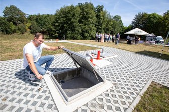 Bauübergabe auf bayerische Art in Plauen: Gegrilltes und Bier auf dem Dach eines XXL-Abwasserspeichers - Pierre Müller, stellvertretender Meisterbereichsleiter beim Zwav, gestattet einen kleinen Blick ins Innere des Regenüberlaufbeckens an der Seumestraße in Plauen. Im Hintergrund wird mit Gegrilltem und Getränken gefeiert.