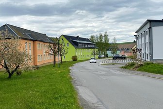 Beethovenstraße in Raschau erhält nicht nur einen neuen Fußweg - Vor den neu gebauten Häusern an der Beethovenstraße (r. im Bild) sind große Stellflächen entstanden, sodass der Fußweg nicht mehr durchgängig ist. Dieser soll künftig vor den farbenfrohen Altbauten (l.) vorbeigehen.