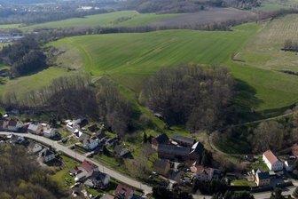 Bei Schönau könnten 20 Hektar zum Solarpark werden - In der Ortslage Schönau könnte auf der grünen Fläche hinter der Baumkante ein etwa 20 Hektar großer Solarpark entstehen. 