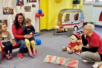 Beierfeld: Wo Knirpse früh lernen, was im Notfall zu tun ist - Auch das Üben eines Notrufs gehörte zum Erste-Hilfe-Kurs. Hier im Bild ruft Hannah (auf dem Schoß von Sandra Köhler sitzend) die „Rettungsleitstelle“ an. Dort ging Nadin Rosmej (r.) ans Telefon.