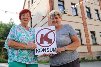 Beim Altstadtfest in Johanngeorgenstadt geht’s um Kultiges aus der DDR - Theresia Feuerherm (links) und Edeltraud Götz mit Deko-Konsum-Schild vorm Ex-Konsum in der Altstadt.