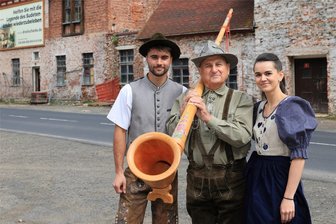 Bekannte Dreckschänke im Erzgebirge wird Kulisse für großes Benefizkonzert - Initiator Gottfried Pöhler (Mitte) mit Marek Plachý Junior und seiner Schwester Zuzana Plachá vor der Dreckschänke in Potůčky.