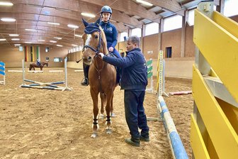 Bekannter Pferdetrainer trainiert Reitschüler in Hotel im Erzgebirge - In der Halle des Reithotels in Eibenstock gibt Trainer Hendrik Falk Reiterin Emma Grunert auf ihrer Stute Grace vor dem Sprungtraining noch einige Tipps mit.