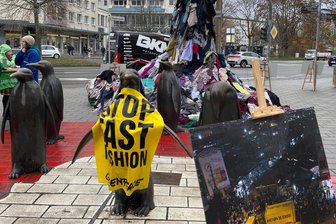 Berg aus Altkleidern neben Chemnitzer Pinguinen - Greenpeace-Aktion in Chemnitz.
