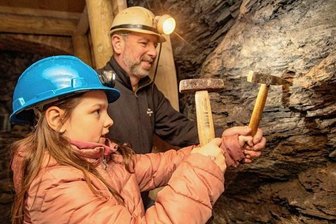 Bergeisen und Schlegel für Kinder - Steffen Gebhardt, Schatzmeister der Vogtländischen Bergknappen, mit Enkelin Nora Zaumzeil in der neuen Schlegelstube. Dort können auch die Jüngsten mit Bergeisen und Schlegel Gestein herausschlagen.
