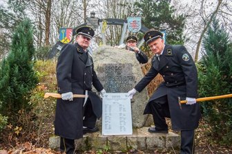 Bergleute gedenken Verstorbenen - Stefan Schrutek, Andreas Rössel und Rainer Müller (von links) vom Bergbautraditionsverein Wismut haben am Samstag die Tafel am Ehrenhain in Bad Schlema aufgestellt, mit der der im vergangenen Jahr verstorbenen Wismutbergleute gedacht wird.