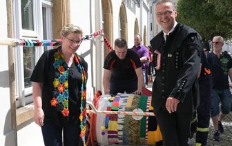 Bergstreittag Schneeberg mit kleinem Gottesdienst und riesigem Schal - Mit dem längsten Schal des Erzgebirges hat der Schneeberger Bürgermeister Ingo Seifert (Freie Wähler/Bika, rechts) am Mittwoch sein Rathaus umwickelt. Grund war die Bügermeister-Wette zum Bergstreittag. Herausforderin Christiane Pelz (links), Inhaberin eines Handarbeits-Geschäfts, hatte gewettet, dass es der Stadtchef nicht schafft, das Gebäude einzuwickeln.