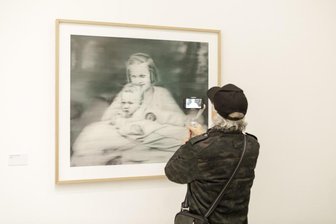 Berlin zeigt Auswahl von Mega-Leihgabe von Malerstar und gebürtigem Dresdner Gerhard Richter - Ein Besucher filmt in der Ausstellung "Gerhard Richter. 100 Werke für Berlin" in der Neuen Nationalgalerie das Werk "Tante Marianne", das den Künstler als Baby und seine Tante zeigt, die Opfer des Euthanasieprogramms der Nazis wurde.