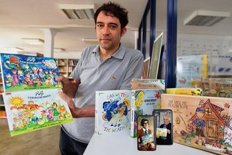 Berliner Illustratorin setzt erneut auf Pappebuch aus Plauen - Sachsendruck-Geschäftsführer Ralf Fischer zeigt das neue Pappebuch "Rolfs Liedergeheimnisse".