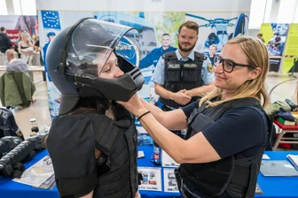 Berufsmesse an Oberschule im Erzgebirge: Mancher weiß schon genau, was er will - Die Achtklässlerin Tamia (v.l.) bekam von Christian Schliemann und Claudia Poller von der Bundespolizei aus Chemnitz Hilfe beim Anziehen einer Körperschutzausstattung.