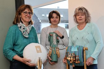 Besondere Schaufenster im Erzgebirge: So international ist Klöppeln - Anita Weigert, Janka Sprunk und Kerstin Sadowski (v. l.) zeigen, wie vielfältig Klöppeln sein kann. Gezeigt werden unter anderem ein Honiton-Kissen aus England, ein spanisches Kissen und ein Klöppelkissen mit Ständer aus Italien.