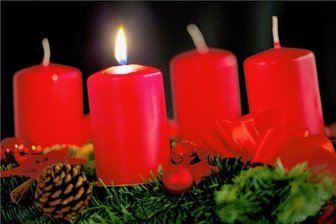 Besondere Weihnachtspost für Senioren in Flöha - Die erste Kerze brennt an einem aus Tannenzweigen geflochtenen Adventskranz.