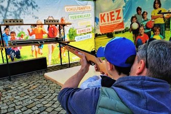 Besucher verwundert über Zielschießen auf Kinderfoto bei Auerbacher Familienfest - Zielschießen am Stand des Waldparks Grünheide beim Auerbacher Familienfest am Sonntag: Einige Besucher waren wegen der Kulisse hinter den Zielboxen irritiert.