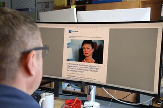 Betrug mit Kryptowährung häuft sich in Region Zwickau: „Täter quetschen Betroffene bis zum letzten Hemd aus“ - Ein Ermittler sitzt am Rechner vor einem vermeintlichen Medienartikel. Darin wird der Eindruck erweckt, Sahra Wagenknecht gebe Tipps zu Investitionen in Kryptowährung. Mit solchen Maschen wollen Betrüger potenzielle Opfer ködern.