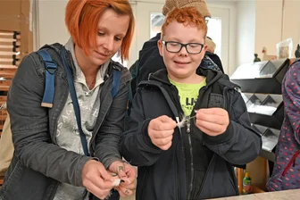 Bettgeschichten aus dem Freiberger Schlafmuseum: Wo die älteste Bettfedern-Reinigung der Welt steht - Fingerspitzengefühl, Kondition und Können gefragt: Im Federnschleißen haben sich Stephanie Euringer und Sohn Bryal im Schlafmuseum Freiberg versucht.