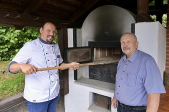 Bier, Brot und Käse wie anno dazumal: Fest bei Zwickau lässt längst vergessene Aromen aufleben - Der Lehmofen am Herrenhaus Vielau wird nur zu besonderen Anlässen angeheizt. Konditormeister Michael Nötzold (links) und Michael Hahn kümmern sich zum Herrenhausfest ums Brotbacken.