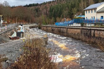 Big Bags sollten Baustelle am Schwarzwasser abschirmen – nun liegen viele zerfetzt flussabwärts - Eingezwängt zwischen Staatsstraße und Schwarzwasser: Diese Stützwand-Baustelle in Breitenbrunn hat es in sich. In der Bildmitte sind noch überspülte Big Bags zu sehen.