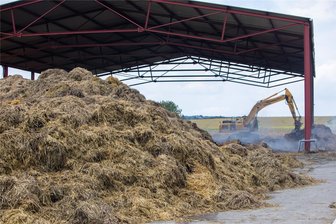 Bilanz des Strohlager-Feuers bei Plauen: 25 Feuerwehrfahrzeuge, 3000 Meter Schlauch und mehr als 70 Stunden Brandbekämpfung - Noch am gestrigen Mittwoch dampft es: Ein Bagger holt Strohballen aus dem Lager. Während des Brandes hätte der Unterstand aus Stahl einstürzen können, sagt die Feuerwehr.