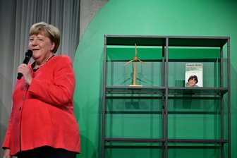 Bilder des Tages vom 03.06.2026 - Angela Merkel (CDU), Bundeskanzlerin a.D. und ehemalige Bundesumweltministerin, spricht auf der Bühne beim Festakt "Seit 40 Jahren NaturVerbunden" zum 40. Jubiläum des Bundesumweltministeriums im Café "Moskau", während im Hintergrund ihr Buch mit dem Titel „Der Preis des Überlebens“ zu sehen ist.