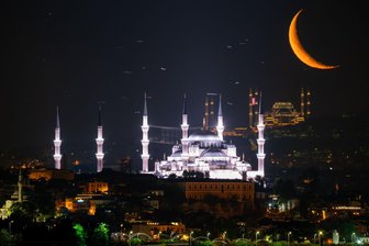 Bilder des Tages vom 12.06.2026 - Der Mond ist aufgegangen. In diesem Fall über der Blauen Moschee (vorne) in Istanbul. 