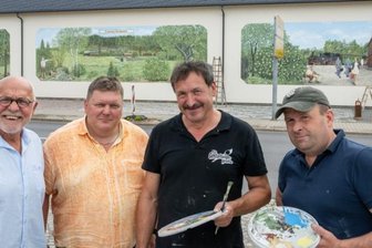 Bilder erinnern an Kleinbahn nach Sayda - Firmeninhaber Andreas Adam (von links) und Geschäftsführer Steffen Schuck von der Saydaer Straßen-, Tief- und Ingenieurbaufirma Adam freuen sich über die drei Wandbilder, die Andreas Schott und Eduard Reiswich an die Fassade des Betriebes gemalt haben. 