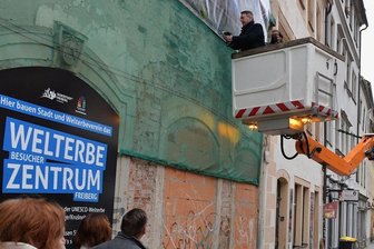 Blick aufs künftige Welterbezentrum in Freiberg - Ein Werbebanner kündet in der Petersstraße vom künftigen Welterbezentrum. Freibergs Oberbürgermeister Sven Krüger brachte am Dienstag symbolisch die letzte Schraube an.