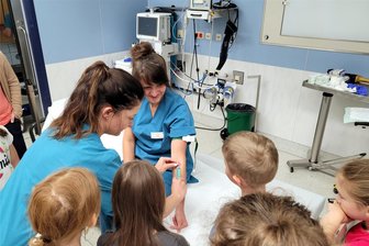 Blick hinter die Kulissen: Hortkinder besuchen Notaufnahme in Zschopau - Schwester Isabel Meier (l.) zeigt den Mädchen und Jungen, wie ein venöser Zugang gelegt wird.