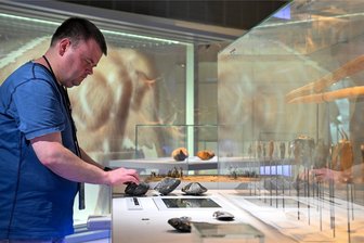 Blind ins Museum: Wo Chemnitz vor der Kulturhauptstadt noch aufholen muss - Kai Weser erkundet das Archäologiemuseum Smac mit Händen und einem Audioguide, auf dem eine Frauen- und eine Männerstimme die Exponate erklären.